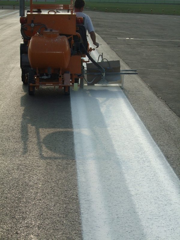 Markierungsmaschine beim Aufbringen der Taxiway-Markierung am Flughafen
