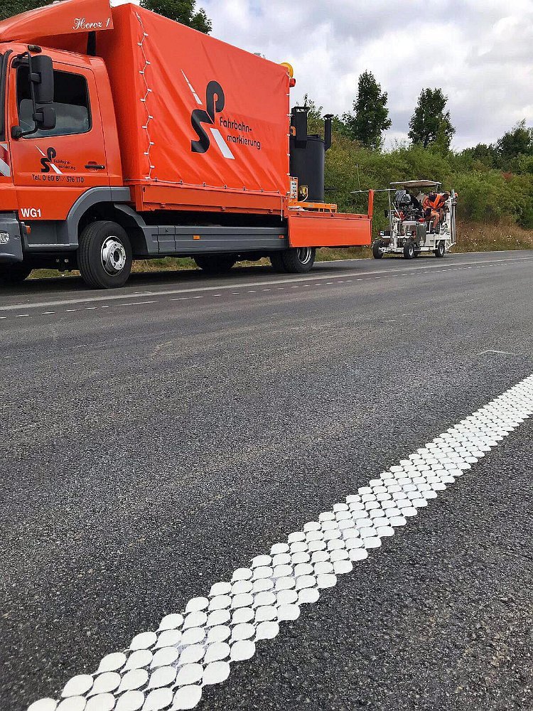 Fahrbahnmarkierungen auf frisch asphaltierter Fahrbahn – neue Spurmarkierungen