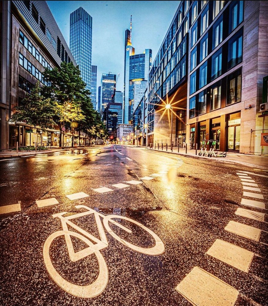 Fahrradstreifen-Markierung in Frankfurt am Main – Nachtaufnahme mit beleuchtetem Stadtpanorama